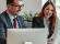 Business man and woman utilizing AI technology on a computer for enhanced productivity.